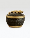 A candle with the intoxicating scent of pink champagne is encased in this vessel with the texture of crocodile skin, handcrafted of fine black Limoges porcelain with 14k goldplated accents. Includes fitted lid with a clasp sculpted in the shape of an crocodile. Handcrafted porcelain 6H X 4 diam. Imported 