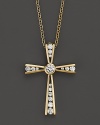 Diamonds set in a 14K yellow gold cross.