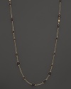 Round and oval grey enamel stations and a diamond highlight this gold chain necklace.