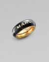 A simple band of black enamel displays the designer's imprint in raised golden letters. Enamel Brass Width, about ¾ Adjusts from Size 6 to Size 8 Imported