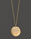 A scattering of diamonds lights up a 14K gold medallion pendant.