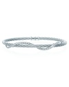 A twist of diamonds and white gold winds around stainless steel bangle. By Charriol.