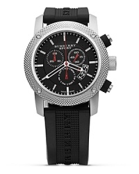 A cool and current look from Burberry Sport. The three eye chronograph has a round dial in black with white and red accents. Textured bezel and black rubber strap.