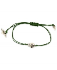 Heavy metal. This RACHEL Rachel Roy bracelet showcases a skull charm with glass stone accents. An adjustable green waxed cotton cord holds it all together. Set in silver tone mixed metal. Approximate diameter: 1/4 inch. Adjustable from 1 inch to 7-1/4 inches.