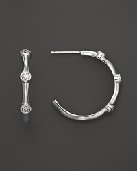 Three faceted diamonds sparkle from 18K white gold hoops from Roberto Coin.