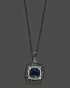 Black and white diamonds frame a faceted London blue topaz, set in 14K white gold with a rhodium chain.