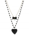 Show your love for the dark side. Betsey Johnson's two-row pendant features a black heart with black-colored crystal accents, black bow with round-cut crystal accents and gold tone chain with black faceted beads. Crafted in antiqued gold tone mixed metal. Approximate length: 16 inches + 3-inch extender. Approximate drop: 3-1/2 inches.