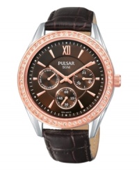 Like a freshly picked rose, this chic timepiece from Pulsar brings grace wherever it goes. Crafted of brown croc-embossed leather strap and round rose-gold tone stainless steel case. Bezel crystallized by Swarovski elements. Brown dial with rose-gold tone stick indices at markers, hour and minute hands, minute track, three subdials, logo and Roman numeral at twelve o'clock. Quartz movement. Water resistant to 50 meters. Three-year limited warranty.