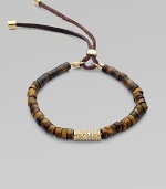 Beautifully textured tiger's eye-inspired beads accented with a center, rhinestone encrusted bead and an adjustable leather closure. Epoxy beadsGlass stonesGoldtone brassLeather cordDiameter, about 2½ stretchableLeather slide adjusterImported 