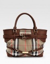 Iconic Burberry check makes a statement in this roomy leather-trimmed carryall, finished with goldtone hardware and buckled leather straps.Double top handles, 5 drop Protective metal feet Two inside zip pockets Cotton lining 14W X 11H X 6D Imported