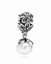 A white freshwater pearl sways delicately from a sterling silver floral charm accented with black zirconia stones. By PANDORA.