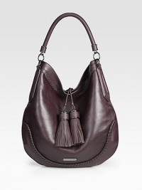 A mix of smooth and pebbled leather with beautiful stitched details throughout and two large tassel embellishments.Top handle, 5 dropMagnetic snap closureOne inside zip pocketTwo inside open pocketsCotton lining14W X 13¼H X 2DImported