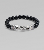 A strand of smooth black onyx beads, capped by dramatic carved raven's heads of sterling silver, clutching the clasp in their beaks. Black onyx Sterling silver Length, about 9¼ Lobster clasp Imported