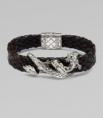 An intricately detailed sterling silver dragon wraps itself around a band of braided leather.SilverBraided leatherPush-lock claspAbout 8½ longAbout ¾ wideImported