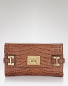 A versatile MICHAEL Michael Kors clutch with glamazon goldtone hardware and organized interior pockets.