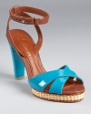 Glossy patent leather in a tropical turquoise hue lends warm weather style to a stunning pair of sandals from Delman.