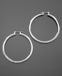 GUESS dresses up classic hoop earrings with sparkling pave crystal details. Crafted in silvertone mixed metal. Approximate diameter: 1-1/2 inches.