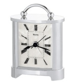 A lustrous dial lends a sophisticated spirit to this tabletop alarm clock by Bulova. Rectangular chrome-finished metal case with handle at top and curved protective lens. Features beep alarm.