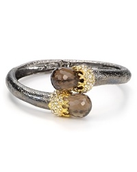 A pair of faceted smoky quartz stones center this Alexis Bittar bangle, finished in hard plated metal.