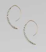 Delicate arcs of 14k gold are set with faceted beads of sterling silver and gold in these elongated, modern hoops with a subtle shimmer.14k yellow gold and sterling silverLength, about 1¼Ear wireMade in USA