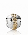 A 14K gold ring of flowers stands out against a shiny silver orb. Charm by PANDORA.