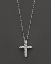 A diamond cross necklace. With signature ruby accent. Designed by Roberto Coin.