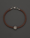 Silver Gucci charm on a braided brown natural leather bracelet.