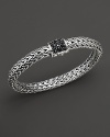 A pavé clasp of black sapphires anchors intricately woven sterling silver.