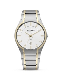 This Skagen watch works the two-tone trend in minimalist style, classically crafted of plated stainless steel with tony, gold accents.