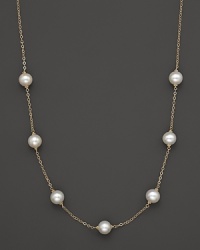 A gold chain necklace with seven freshwater pearl stations.