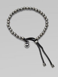 A smooth, beaded design with a logo lock charm and an adjustable leather closure. Gunmetal-finished metalDiameter, about 2.5Slip-on style with adjustable leather closureImported 