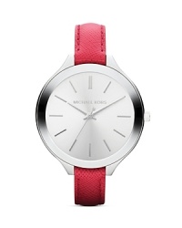 A bold, round dial in pristine stainless steel tops a slim, sophisticated Michael Kors watch set on brightly hued leather strap.