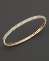 Pavé diamond bangle in 14 kt. yellow gold. Hinged closure.