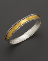 Intricately textured sterling silver frames a bold, gleaming band of 24K. yellow gold. By Gurhan.