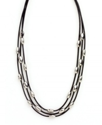 Let sleek beads add extra polish to your look. Nine West's chic three row necklace features leather cords strung with oval-shaped beads in silver tone mixed metal. Approximate length: 16 inches.