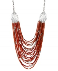 Lavish your look. Kenneth Cole New York's chic statement necklace features rows of red seed beads and silver tone chains. Embellished with silver tone hammered discs. Set in silver tone mixed metal. Approximate length: 23 inches + 3-inch extender. Approximate drop: 5 inches.