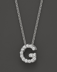 From the Tiny Treasures collection, a diamond G necklace. With signature ruby accent. Designed by Roberto Coin.