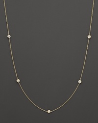 A yellow gold necklace with bezel-set diamond stations. With signature ruby accent. Designed by Roberto Coin.