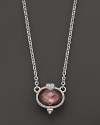 A faceted raspberry crystal oval is detailed with a sparkling white sapphire heart. From Judith Ripka.