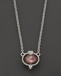 A faceted raspberry crystal oval is detailed with a sparkling white sapphire heart. From Judith Ripka.