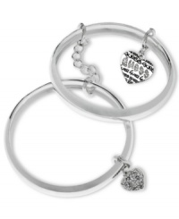 Retro fashion from GUESS. These bangle bracelets are linked together with a chain adding stackable style. Featuring dangling heart charms with black epoxy and crystal accents. Crafted in silver tone mixed metal. Approximate diameter: 2-1/2 inches. Approximate drop: 1 inch.