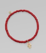 The hamsa, a traditional protective amulet, is encrusted with diamonds and accented with one ruby as it hangs from a stretchy strand of richly colored coral beads. Diamonds, 0.05 tcw Coral 14k yellow gold Diameter, about 2 (unstretched) Charm length, about ½ Imported