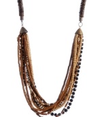 Create a subtle layered effect with earth tones. Brown, black and white glass and wooden beading make Haskell's trendy long necklace a neutral go-to that blends with any look. Set in brass-plated mixed metal. Approximate length: 33 inches.