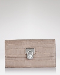 A logo-stamped lock detail toughens up this sleek crocodile-embossed leather wallet. By MICHAEL Michael Kors.