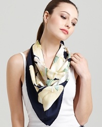 A navy blue oversized silk scarf featuring an elegant magnolia print and signature logo at hem.