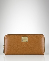 A slim and sleek zip-around wallet crafted in luxe textured leather from Lauren By Ralph Lauren.