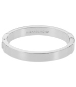 Subtle refinement. A simple layer, like this polished Michael Kors bangle, adds just the right amount of shine. Crafted in silver tone mixed metal, bracelet features a hinge clasp and engraved logo detail. Approximate diameter: 2-1/2 inches.