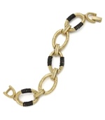 Urban chic. Chunky oval links wrapped with hematite tone chains pop on this trendy Alfani bracelet. Set in gold tone mixed metal. Approximate length: 7-1/2 inches.