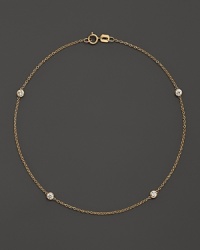 Diamond bezels sparkle from the stations on this dainty 14K yellow gold ankle bracelet.