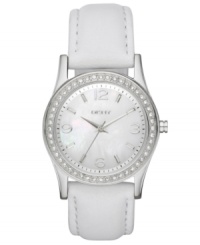 Refined and tranquil, this timepiece from DKNY soothes the mind with each passing second. Crafted of white leather strap and round stainless steel case. Bezel embellished with 48 clear crystal accents. White mother-of-pearl dial features silver tone numerals at three, six, nine and twelve o'clock, stick indices, minute track, silver tone three hands and logo at twelve o'clock. Quartz movement. Water resistant to 50 meters. Two-year limited warranty.